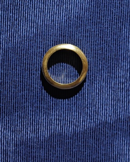 Smooth gold band resting on navy corduroy